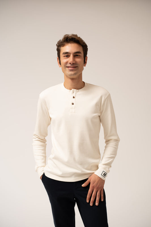 Man wearing a white long-sleeve shirt with a collar on a plain background